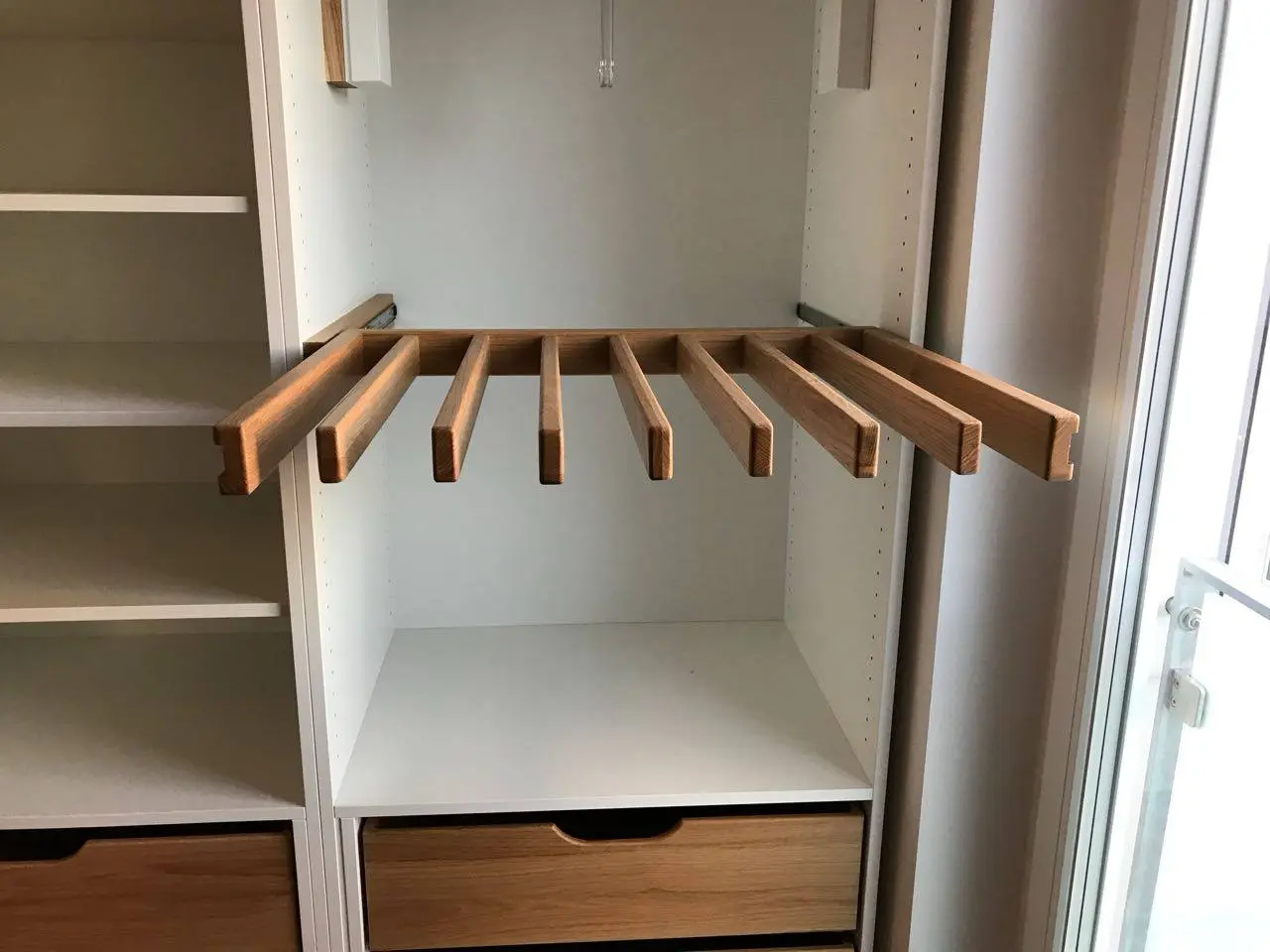 Ausziehbarer Hosenhalter aus Holz in einem maßgefertigten Einbauschrank