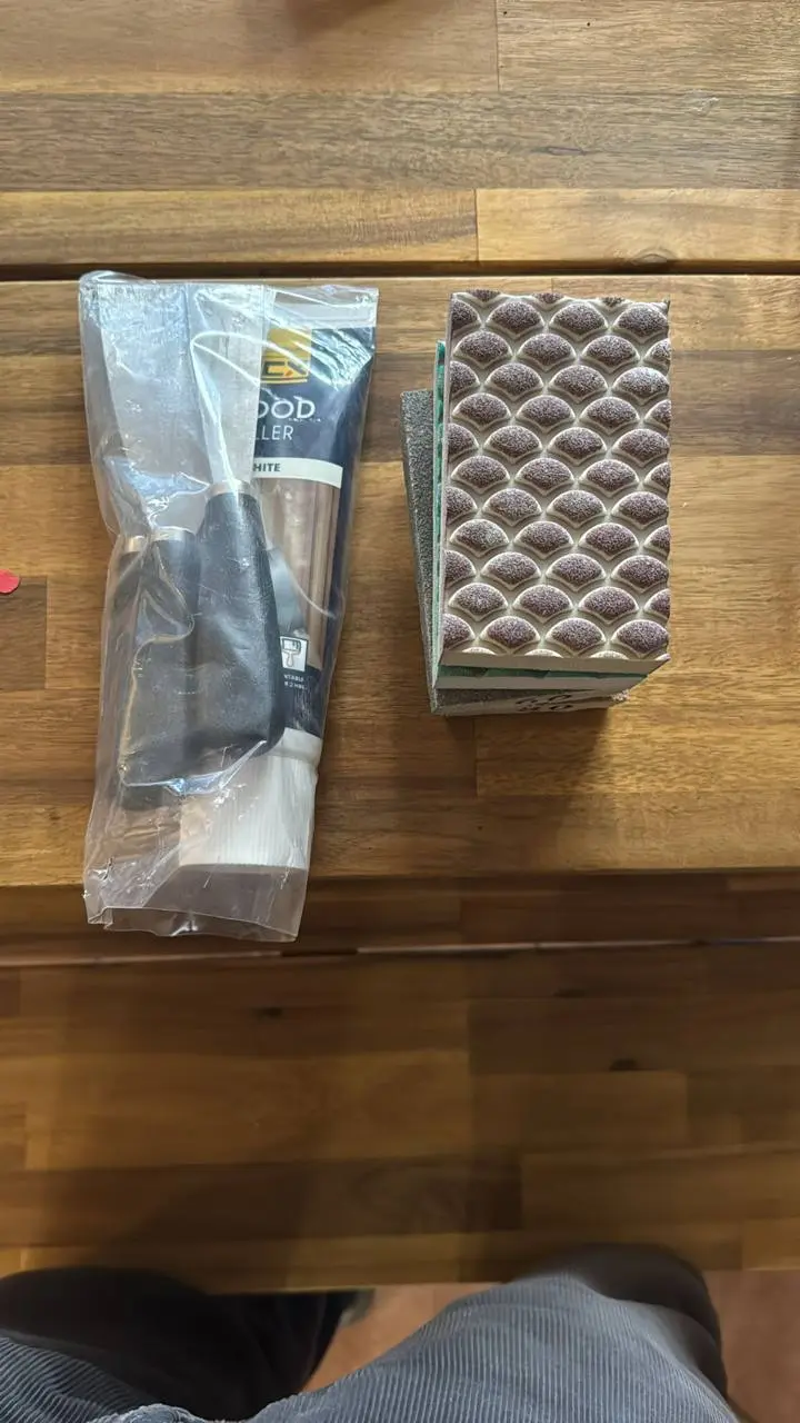 Werkzeuge und Schleifmittel für die handwerkliche Oberflächenbearbeitung auf einer Holzfläche